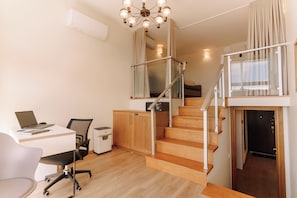 A modern apartment with a wooden staircase, a desk with a laptop, and a chair. - Black Sea Point Apartments 5 (Batumi)