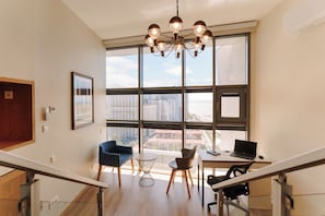A modern office space with a large window, a desk with a laptop, and a chair. - Black Sea Point Apartments 5 (Batumi)
