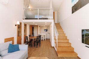 A modern interior with a staircase, a dining area, and a living space. - Black Sea Point Apartments 5 (Batumi)