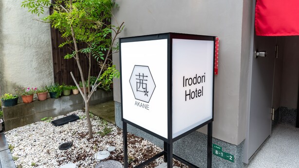 A signboard for Irodivari Hotel with a hexagonal logo and the name 'AKANE' below it. - Irodori Hotel AKANE (fukuokashi,hakataku,kamigofukumachi)