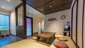 A traditional Japanese room with tatami flooring, a low wooden table, cushions, a shoji screen, and a clock on the wall. - Irodori Hotel AKANE (fukuokashi,hakataku,kamigofukumachi)