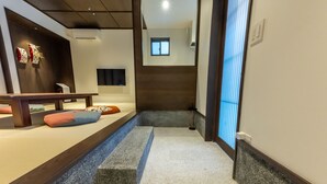 A hallway with a bench, a small step, and a wall-mounted air conditioner. - Irodori Hotel AKANE (fukuokashi,hakataku,kamigofukumachi)