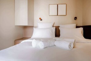 A hotel room with a bed, two bedside tables, and a wall-mounted light fixture. - Babylon Popincourt 22 (Paris)