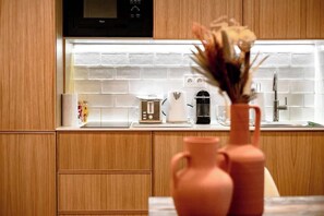 Eine Küche mit Holzausstattung, einer Mikrowelle, einem Toaster und einer Vase mit Blumen.