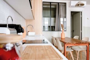 Eine moderne Küche mit einer Holzinsel, weißen Geräten und einem Essbereich mit einem Holztisch und Stühlen.