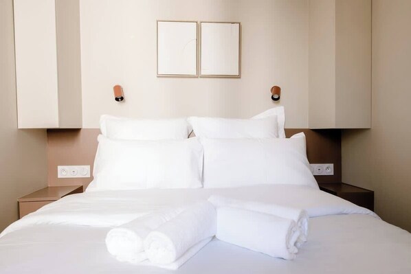 Ein Hotelzimmer mit einem Bett, zwei Nachttischen und einer Wandleuchte.