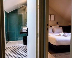 Ein Hotelzimmer mit einem Bett, einem Badezimmer mit türkisfarbenen Fliesen und einem Schachbrettmuster-Boden.