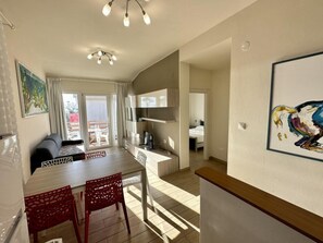 Ein modernes Hotelzimmer mit Essbereich, Fernseher und Balkon mit Blick.