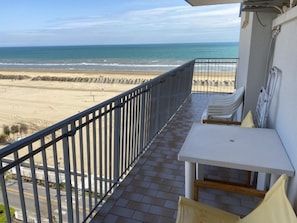 Ein Balkon mit Blick auf Strand und Meer.