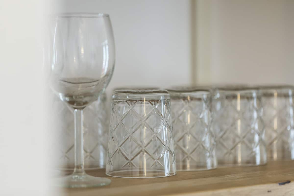 A row of clear glassware on a wooden surface.