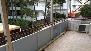 A balcony with a tiled floor, metal railing, and an air conditioning unit. - Spacious stay for families close to the beach (Bibione)