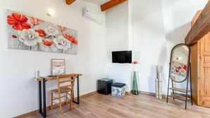 A room with a wooden desk, chair, and a large floral painting on the wall. - Guest Room “Coquelicot” with Wi-Fi and Air Conditioning (Domazan)