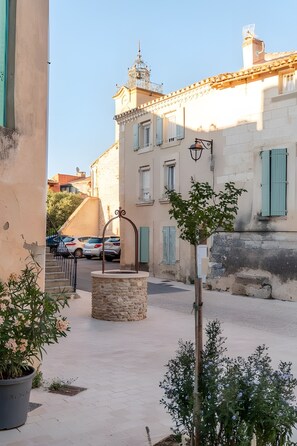 A narrow street with stone steps leading to a building with a bell tower.