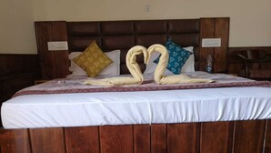 A bed with a wooden headboard, white bedding, and decorative pillows.