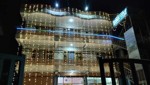 A multi-story building with balconies and string lights.