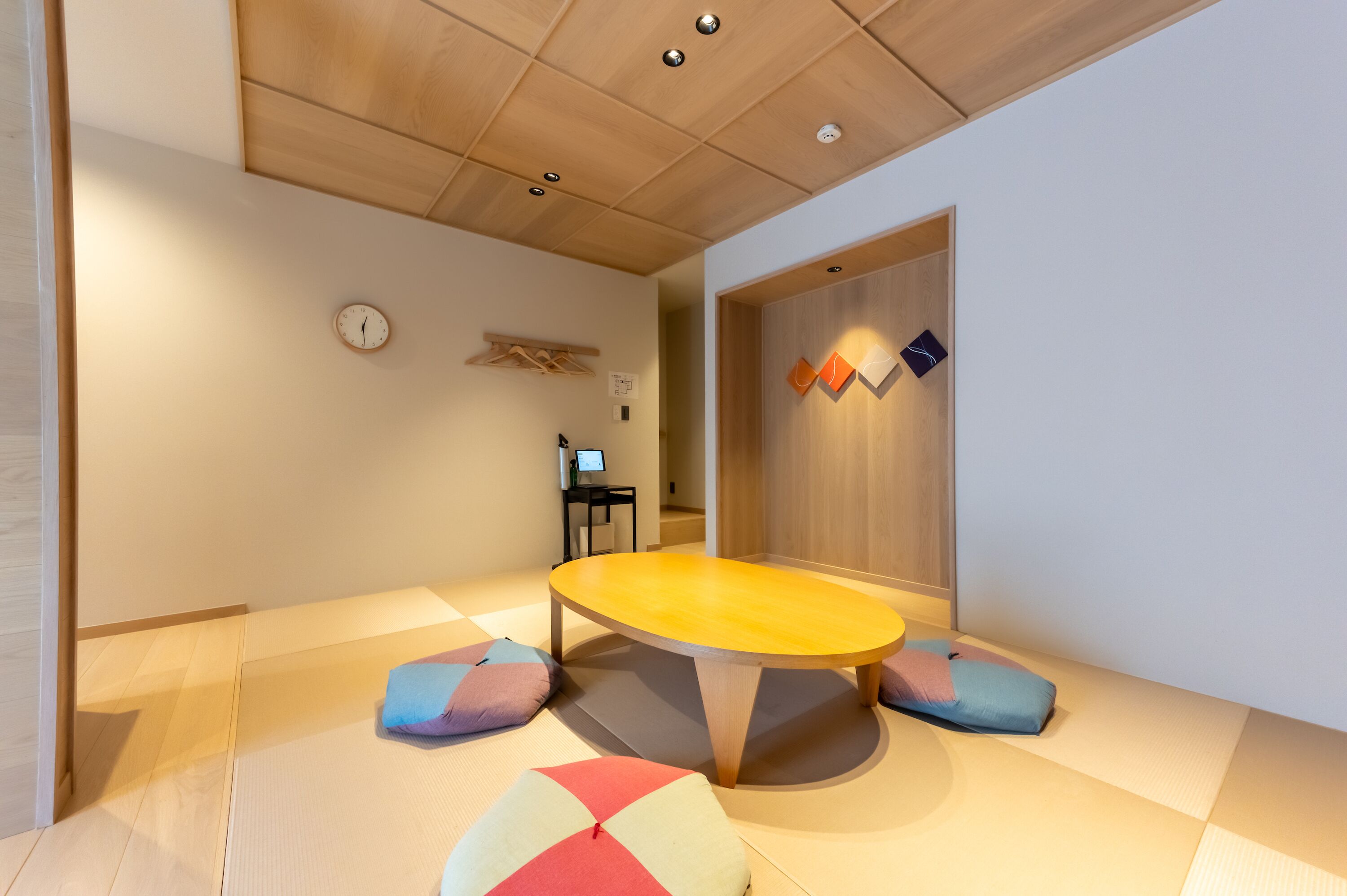Een kamer met tatami vloerbedekking, een lage houten tafel en kussens.