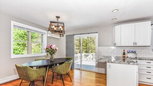 Una cocina moderna con comedor, ventanas amplias y vistas a una terraza.