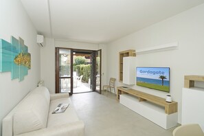Ein modernes Wohnzimmer mit einer Couch, einem Flachbildfernseher und einer Holzbank.