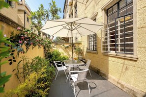 Habitación cuádruple Confort, cocineta, en el área del patio | Restaurante al aire libre