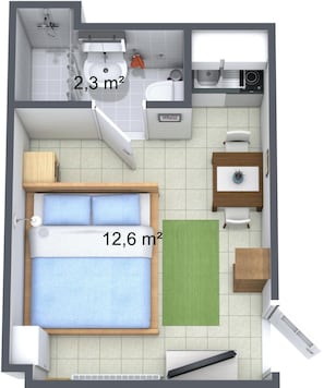 A bedroom with a bed, a small bathroom, and a desk area.