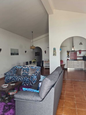 Ein Wohnzimmer mit einer Couch, einem Couchtisch und einem Essbereich mit Stühlen und einem Tisch.