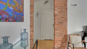 A room with a brick archway, a white door, and a colorful abstract painting on the wall. - Parkowa 19 - Beach & Chill Sopot (Sopot)