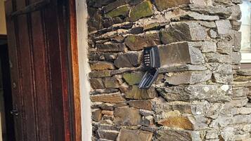 A stone wall with a door and a mailbox.
