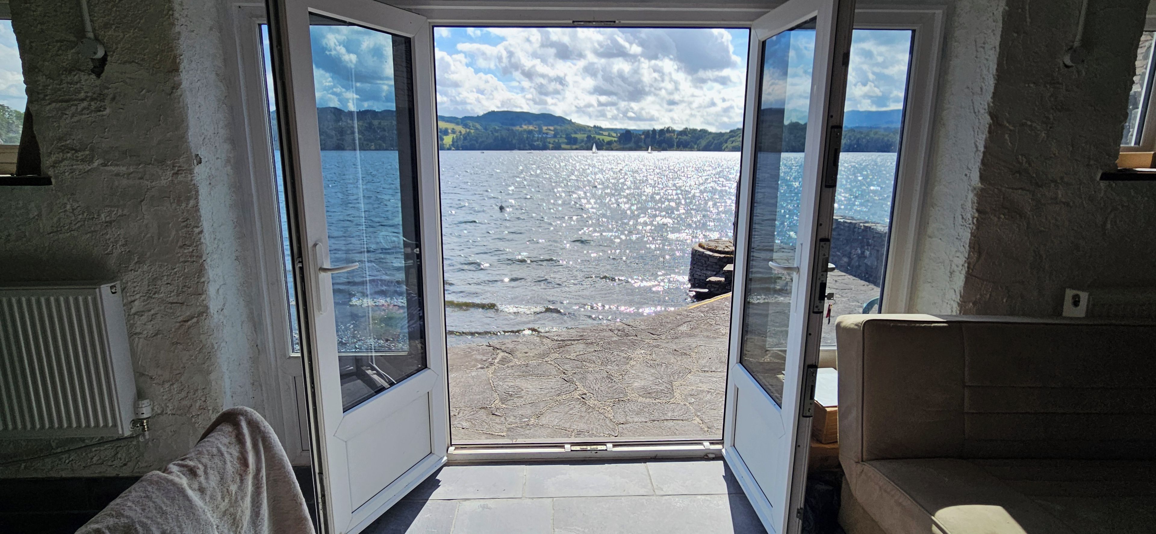 Una habitación con vista a un lago y un bote.