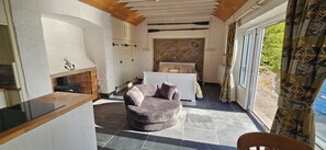 Una habitación acogedora con chimenea, una cama y un rincón de descanso.