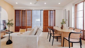 Un salon moderne comprenant un canapé, une table à manger, des chaises et un ventilateur de plafond.