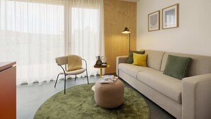 A living room with a sofa, ottoman, chair, and a lamp. - homie stay an der alten dampf (Würzburg)
