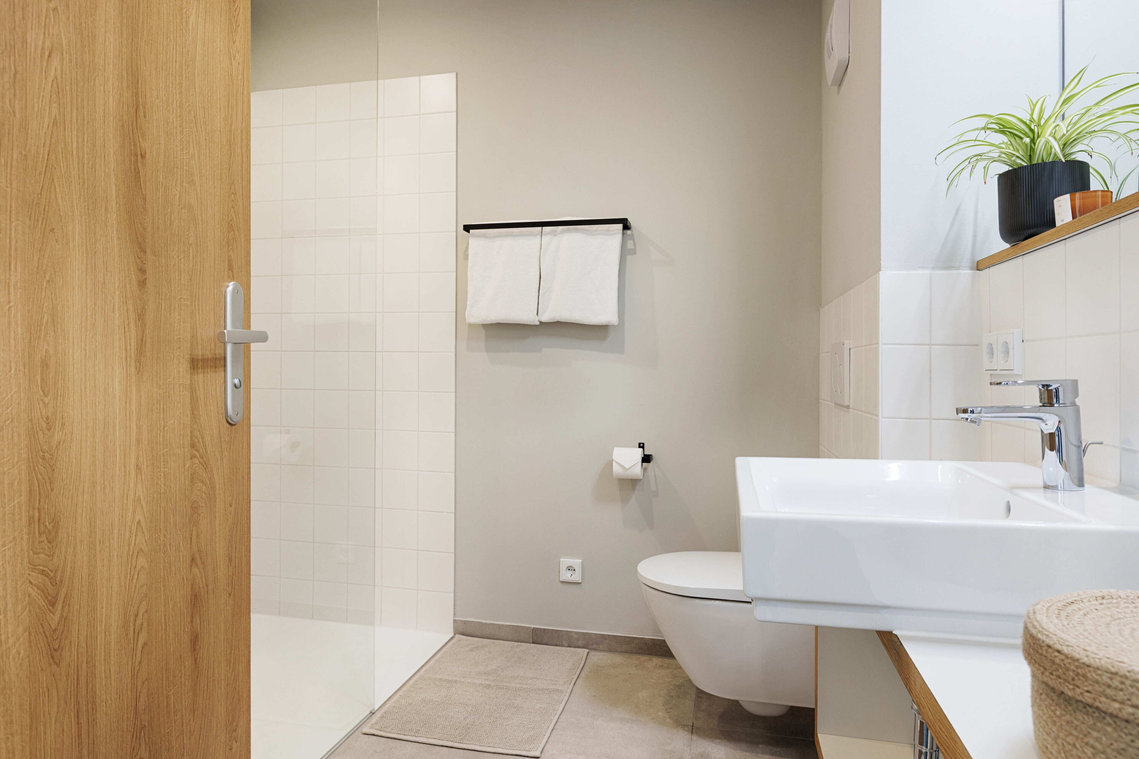 A modern bathroom with a toilet, sink, and shower.