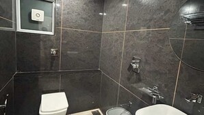 A modern bathroom with a toilet, bidet, and sink.
