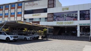 A hotel with a covered parking area, a food court, and a gym.