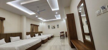 Quarto de hotel com design moderno, com ventilador de teto, iluminação embutida e um espelho grande.