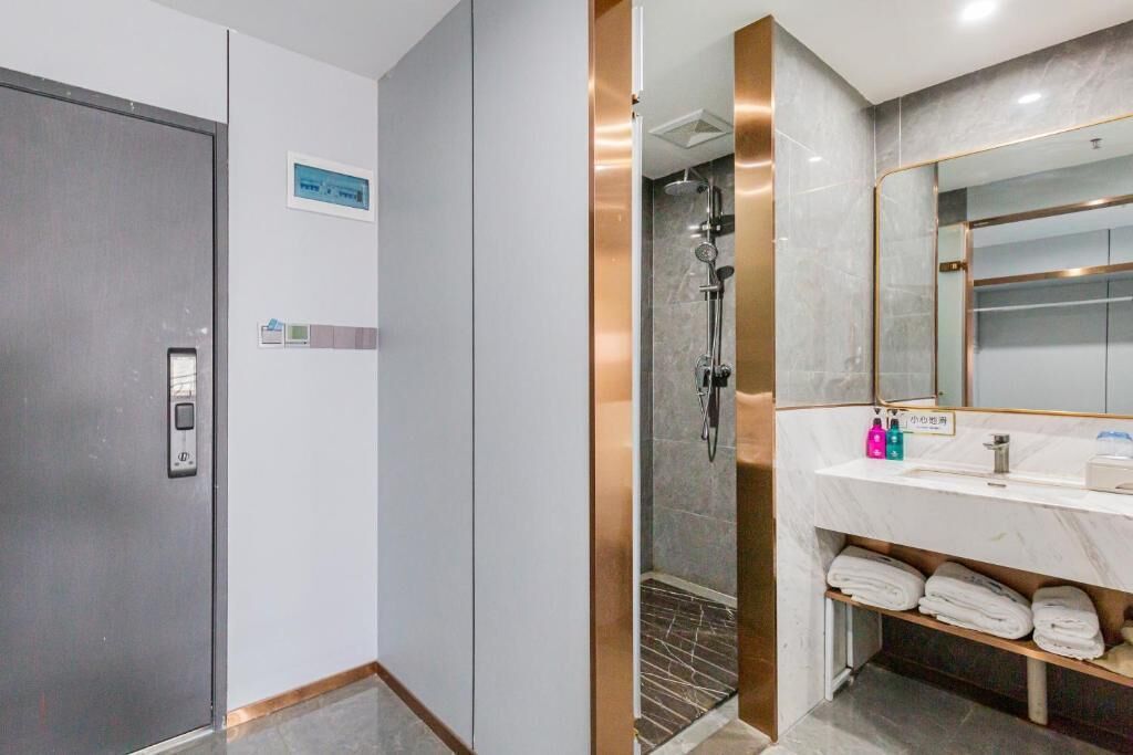 A modern bathroom with a shower, a sink, and a mirror.
