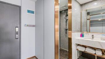 Un baño moderno con ducha, lavabo y espejo.