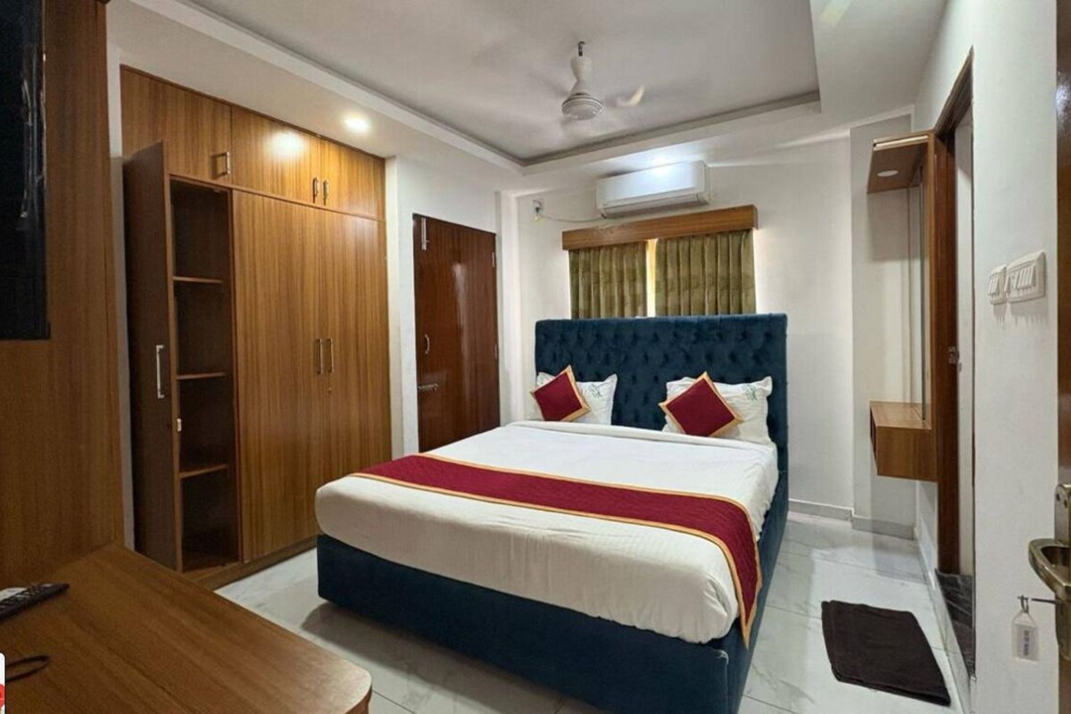 A bedroom with a bed, wardrobe, and a ceiling fan.