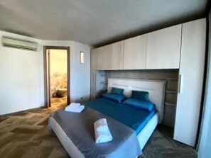 Ein Schlafzimmer mit einem Bett, Nachttischen und einem Kleiderschrank.