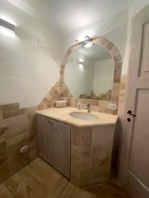 Ein Badezimmer mit Waschbecken, Spiegel und Fliesen.