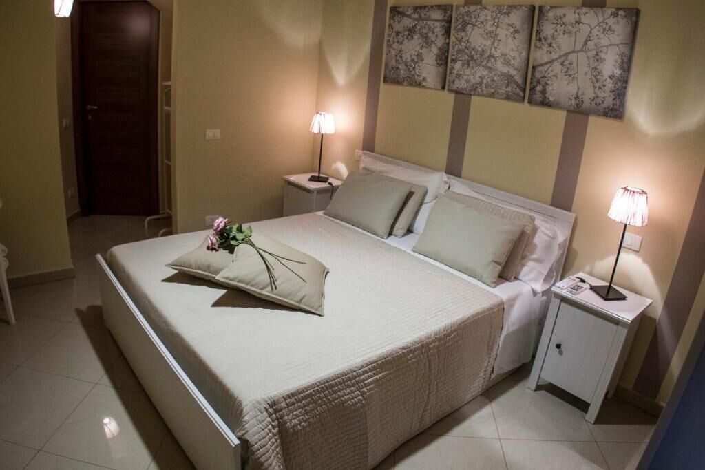 Een keurig opgemaakt hotelkamer met een bed, nachtkastjes en een bedtafel.