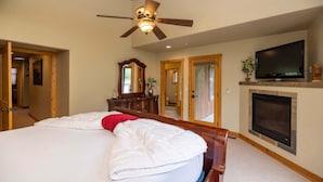 A bedroom with a bed, a ceiling fan, a television, a fireplace, and a mirror. - Cozy 3BR townhome in Durango with mountain views, perfect for families! (Durango)