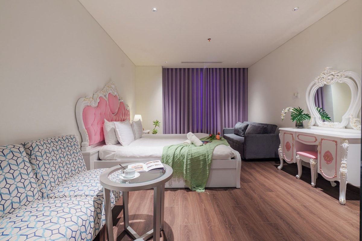 Una habitación de hotel moderna con cama, sofá, escritorio y silla.
