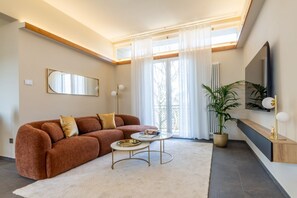Ein Wohnzimmer mit Sofa, Couchtisch und einer Topfpflanze.