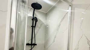 A shower with a glass enclosure and a handheld showerhead. - Charming Studio Steps from City Center (Ghent)