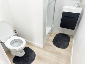A modern bathroom with a toilet, a shower, and a sink. - Charming Studio Steps from City Center (Ghent)