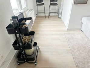 Una habitación con cafetera, una mesita y una cama.