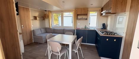 A compact kitchen with a dining area, a built-in stove, and a seating arrangement.
