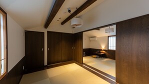 Een traditionele Japanse kamer met tatami vloerbedekking, schuifdeuren en een plafondventilator.