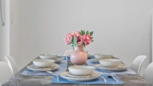 Una tavola imbandita con piatti, ciotole e un vaso di fiori.